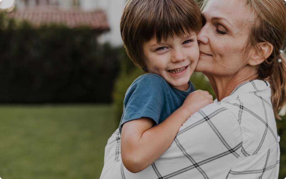 Grandmother embracing a young child in a garden setting at Gosford Doctors